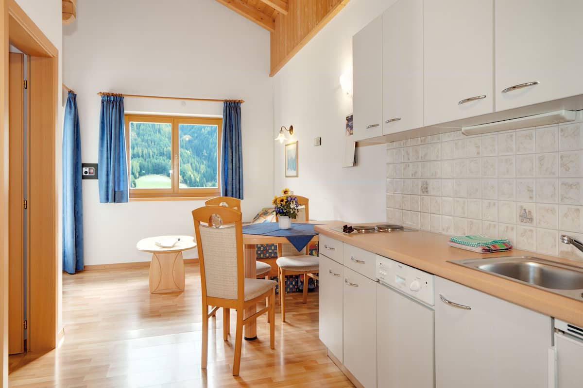 A modern kitchen with white cabinets, a wooden countertop, and a built-in dishwasher.