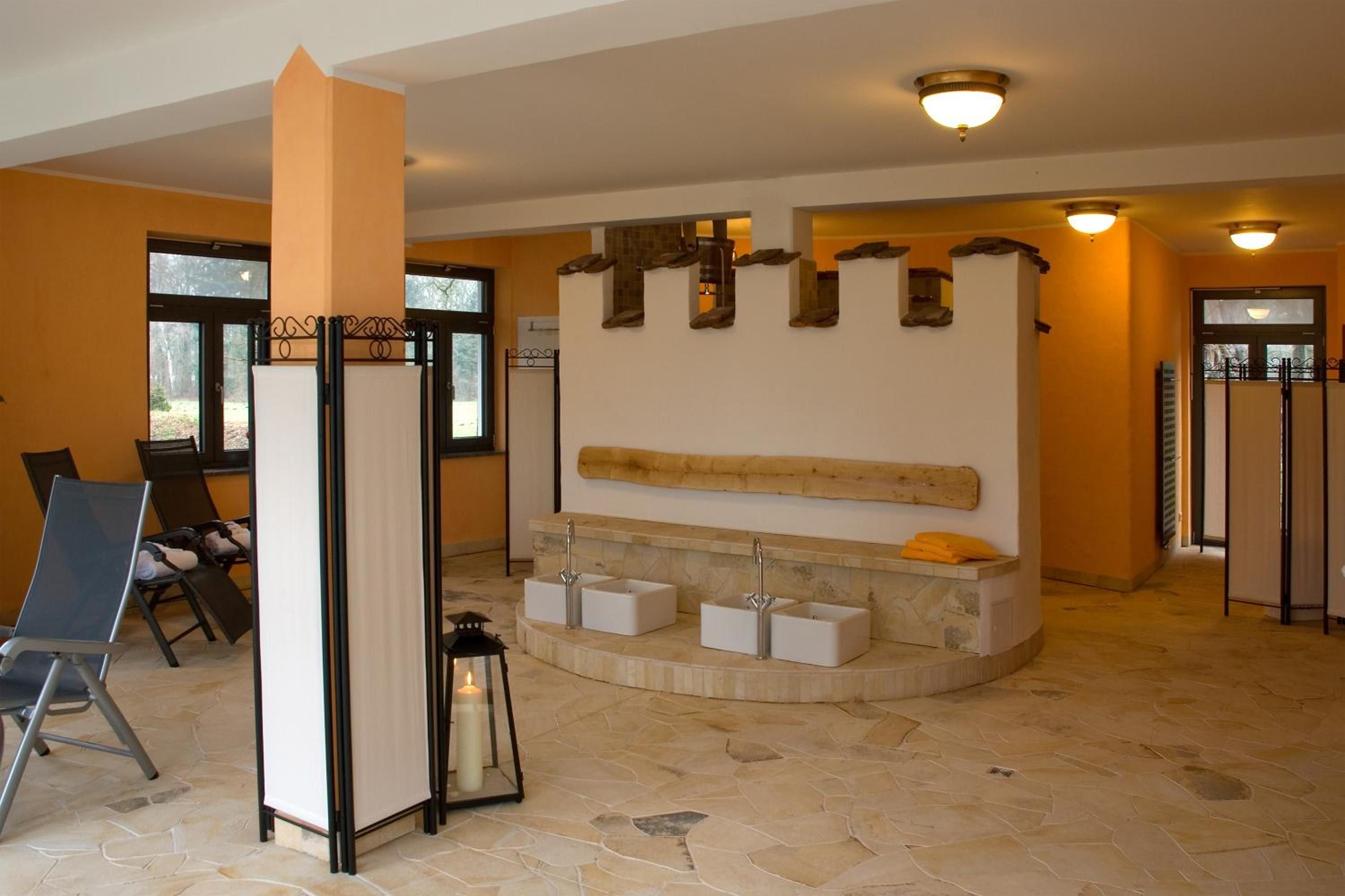 Un bagno con pavimento in pietra, una vasca freestanding e un lavabo sospeso.