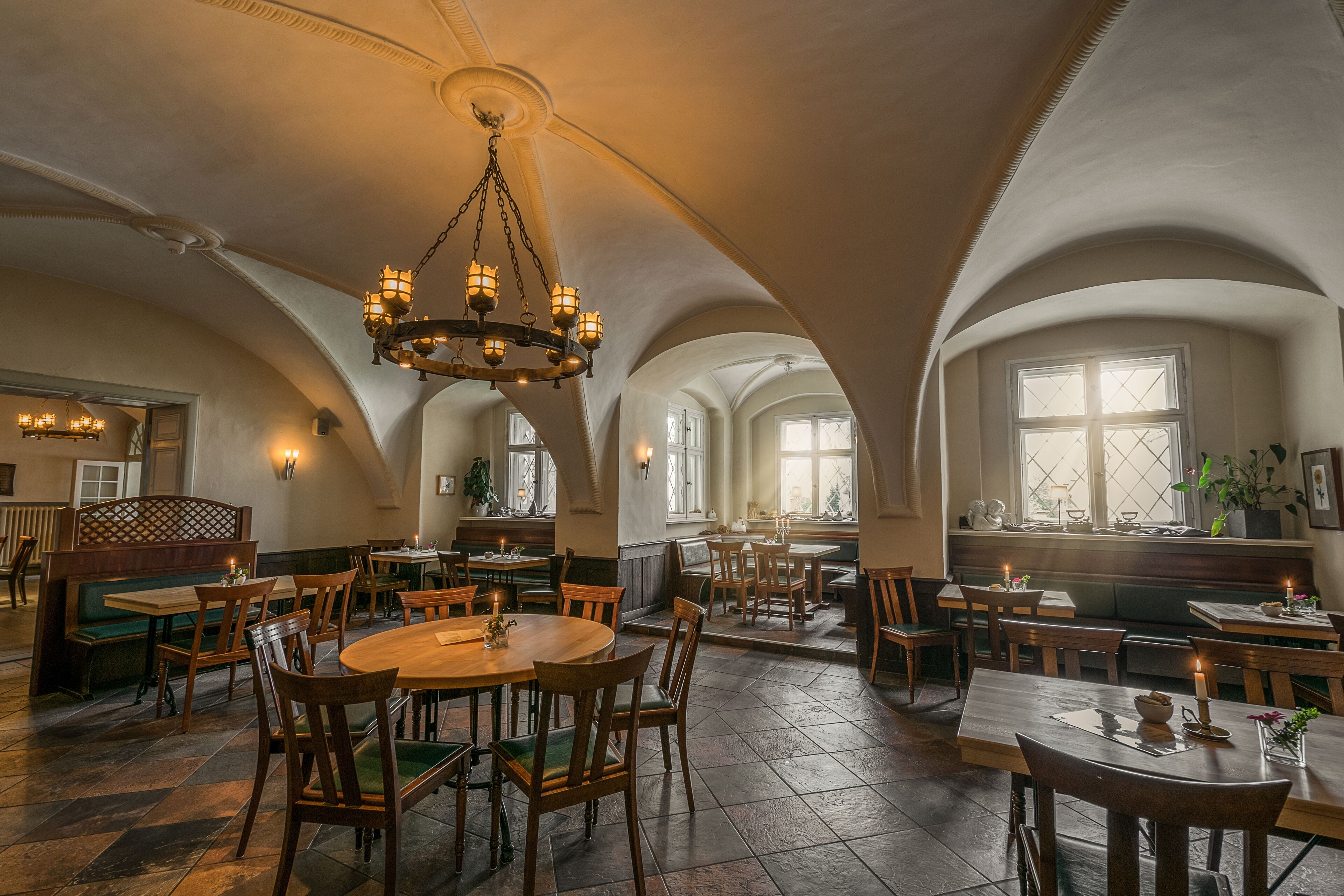 Un vaste espace dédié à la salle à manger, doté de hauts plafonds en arc et de nombreuses tables et chaises.