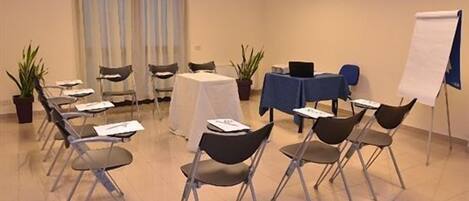 A conference room with tables, chairs, and a whiteboard.