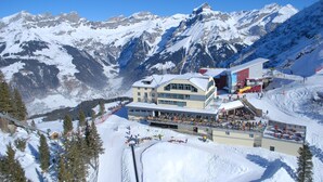 A ski resort with a large building featuring multiple levels and a ski lift. - Berghotel Trübsee (Engelberg)