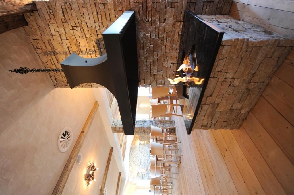 Un espace de bien-être doté d’un mur en pierre, d’une cheminée et d’un plancher en bois.