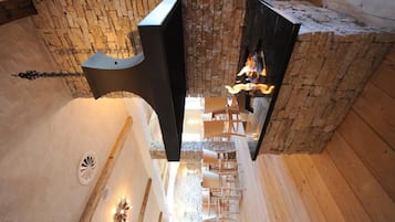 Un espace de bien-être doté d’un mur en pierre, d’une cheminée et d’un plancher en bois.