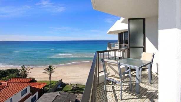Un balcón con vista a la playa y al océano.