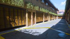 Une rue étroite bordée de portes closes, probablement des chambres d’hôtel, avec une ligne jaune qui indique le chemin.