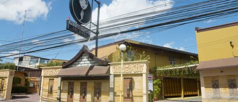 A building with a traditional architectural style, featuring a prominent entrance with a decorative archway and a signboard.