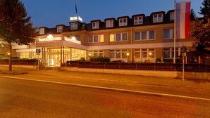Un hotel con un cartello ben visibile, diverse finestre e una bandiera.
