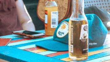 Una mesa con una botella de Corona Extra, una botella de Brisket y una tapa de Corona Extra.