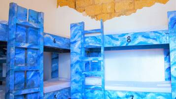 Bunk beds with numbers 5, 6, 7, and 8, in a room with a brick wall and a window.