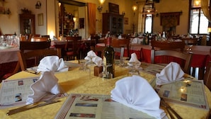 A restaurant with tables set for dining, menus, and wine glasses. - Hotel Due Colonne (San Bonifacio)