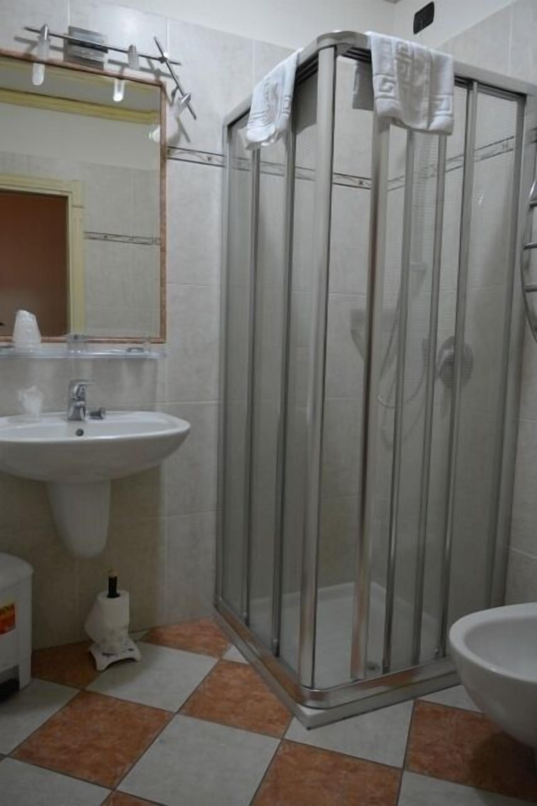 Une salle de bain avec une douche à parois de verre, un lavabo et des toilettes.