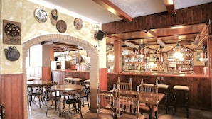 Un pub tradicional con mobiliario de madera, una zona de bar y un arco de ladrillo.