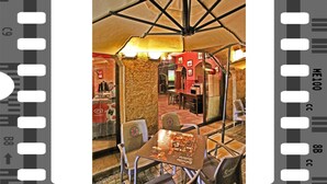Un comedor interior con techo alto, paredes de piedra y una mesa central con sillas.
