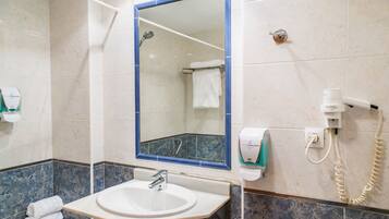 A bathroom with a sink, mirror, towel rack, and a hand dryer.