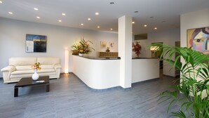 A modern reception area with a curved reception desk, a sofa, and a coffee table.