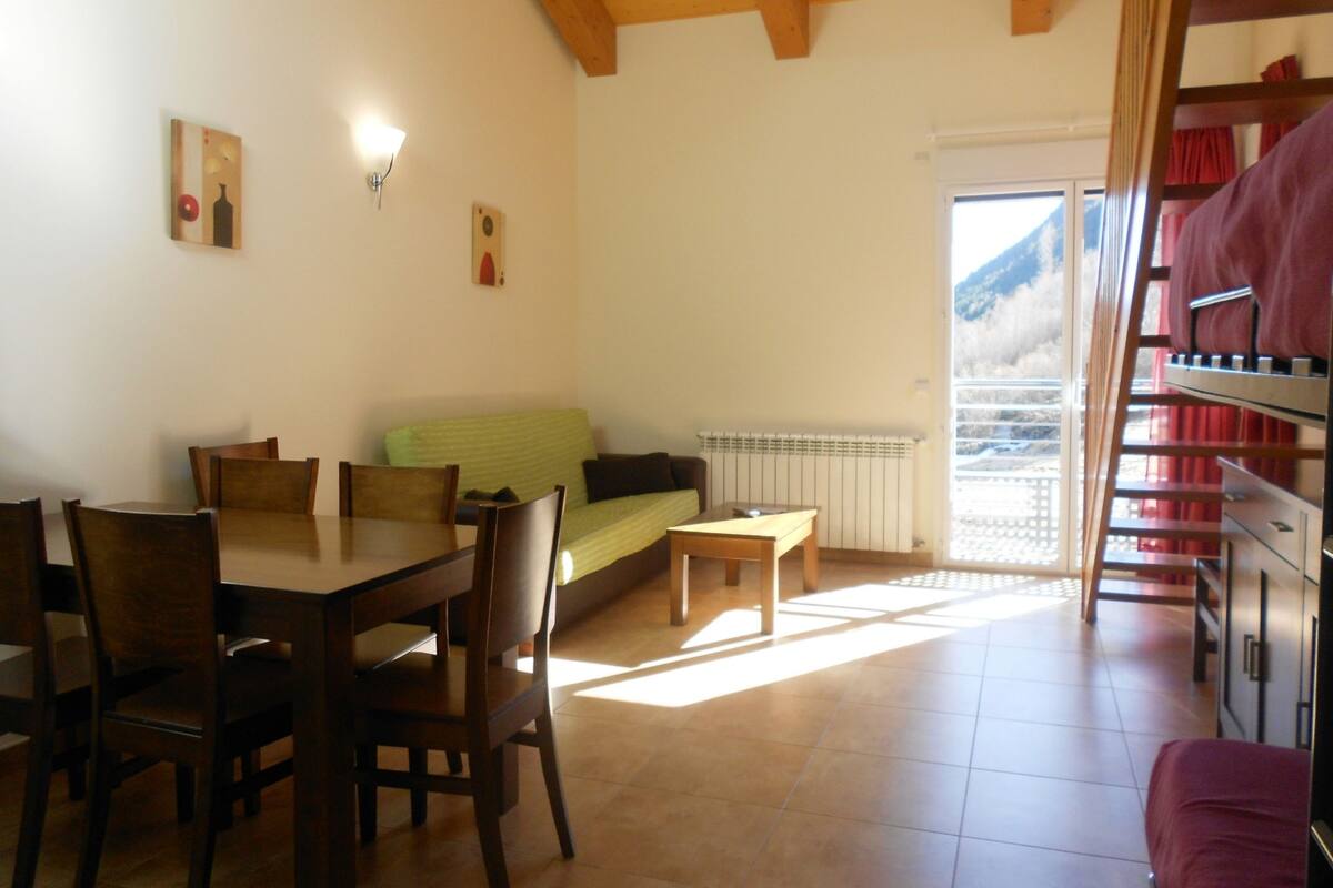 A dining area with a table and chairs, a sofa, and a radiator.