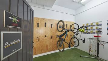 Una habitación con pared de madera, un perchero para bicicletas y alfombra verde.