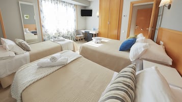 Camera d'albergo con due letti, una scrivania, una sedia, una televisione e un armadio.