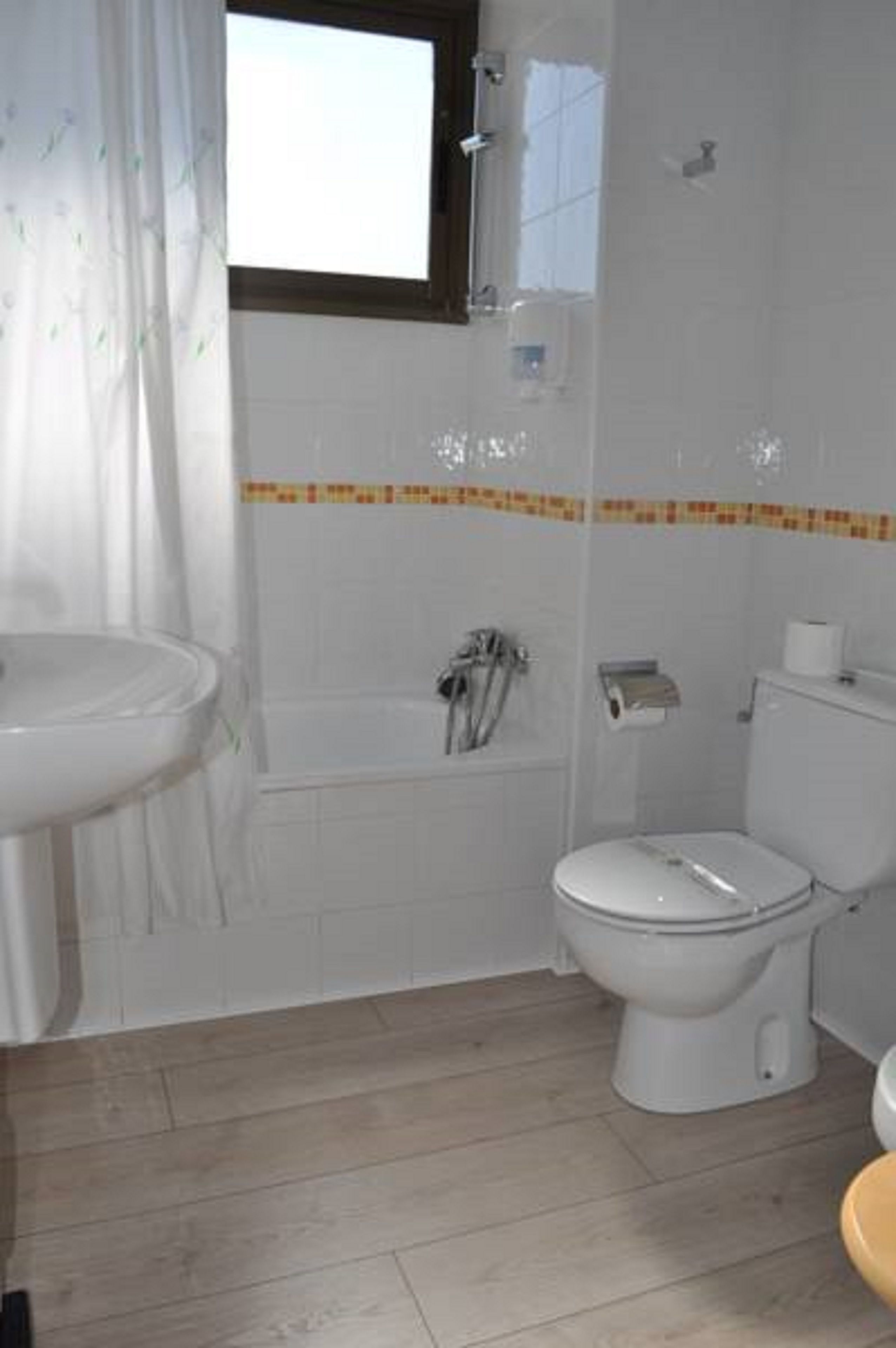 A bathroom with a white sink, toilet, and bathtub.