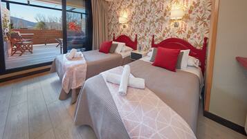 A hotel room with two beds, a balcony, and a view of the outdoors.