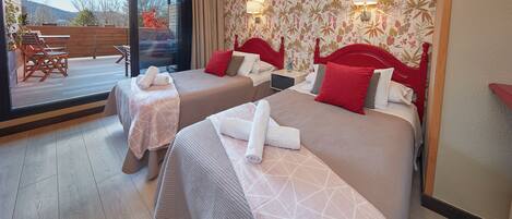 Habitación de hotel con dos camas, un balcón y vistas al exterior.