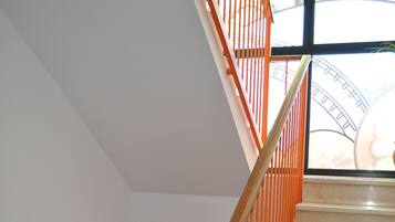 A modern interior with a staircase, orange furniture, and a lamp.