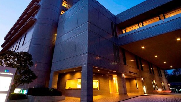 A modern building with a prominent cylindrical structure and a flat roof. - Hotel International House Osaka (Osaka)