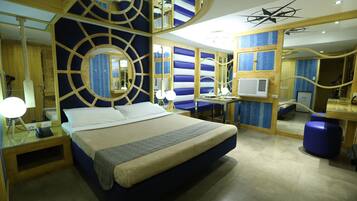 A modern hotel room with a large bed, bedside tables, a desk, and a chair.