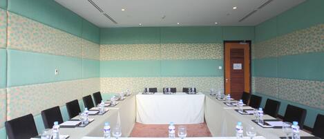 A conference room with a long table, chairs, water bottles, and nameplates.