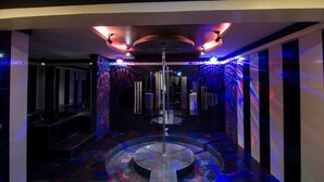A modern hotel lobby with a central column, reflective surfaces, and ambient lighting. - Victoria Court Hillcrest - Pasig (Pasig)