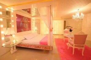 Quarto com cama, mesa de cabeceira, espelho e candelabro.