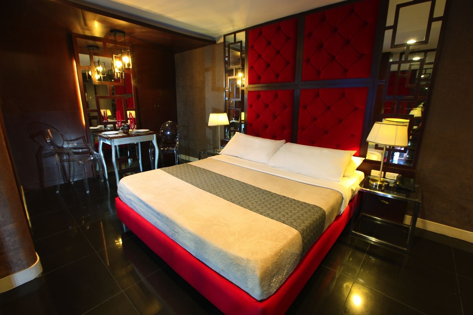 Een hotelkamer met een groot bed, een bureau en stoelen.