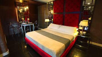 Een hotelkamer met een groot bed, een bureau en stoelen.