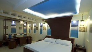 A modern hotel room with a large bed, a desk, and a seating area. - Victoria Court Hillcrest - Pasig (Pasig)