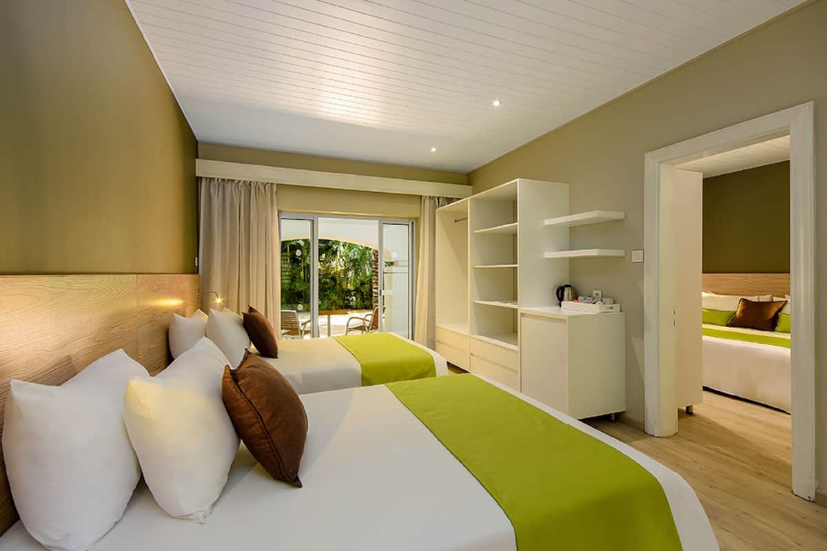Een hotelkamer met twee bedden, een ruime inloopkast en uitzicht op de omgeving.