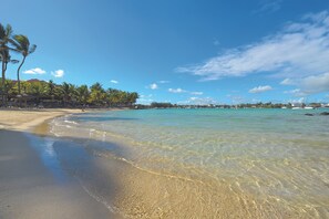 On the beach, white sand, sun-loungers, beach towels