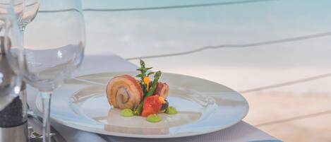 A table set with a plate of food, a glass of water, and a salt shaker.
