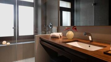 Ein modernes Badezimmer mit einem großen Spiegel, zwei Waschbecken und einer Duschkabine aus Glas.