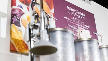A coffee machine and several stainless steel containers on a wall.