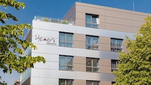 Edifici d'hotel de diverses plantes amb un disseny modern, que destaca un cartell important per a "Heiner's Parkhotel" a la façana.