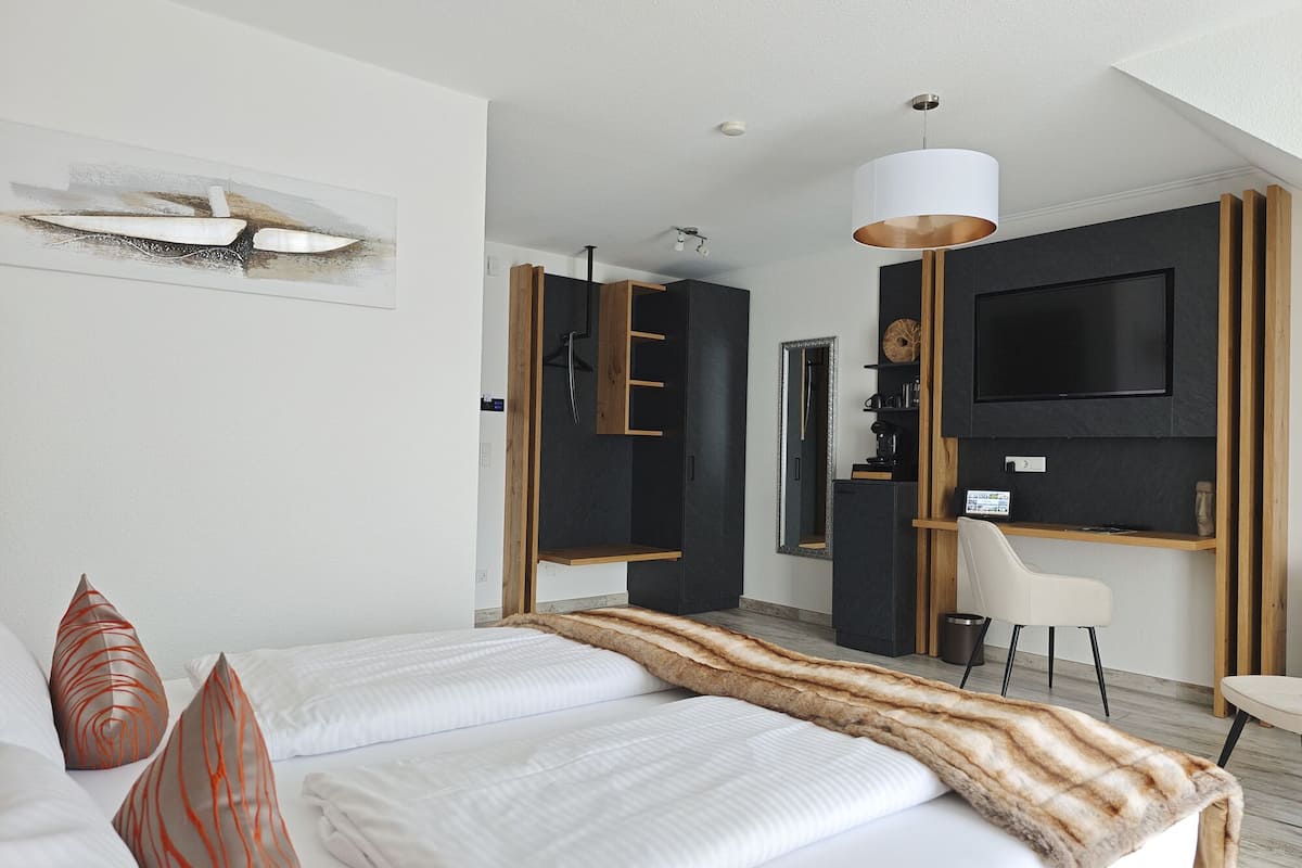 Une chambre d’hôtel moderne équipée d’un grand lit, d’un bureau, d’une télévision et d’un coin salon.