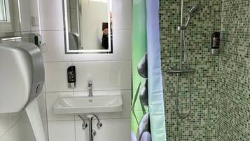 Ein modernes Badezimmer mit Waschbecken, Spiegel und Dusche.