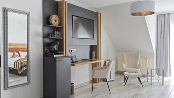 Camera d'albergo moderna con angolo cottura, un grande specchio, una poltrona confortevole e vista sulla città.