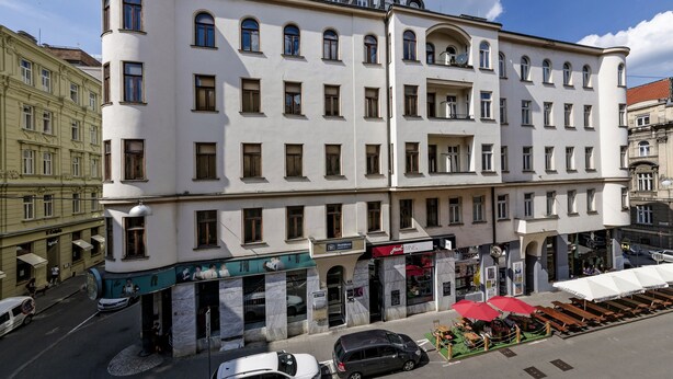 A multi-story building with a classical architectural style, featuring a ground floor with commercial establishments and a second floor with residential units. - Penzion Dvorákova (Brno)