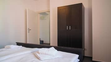 Una camera d'albergo con un letto, un armadio e uno specchio.
