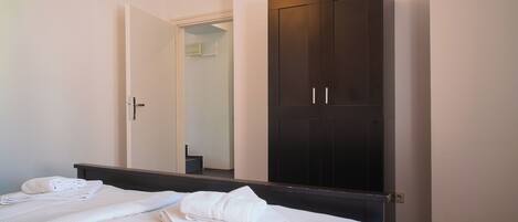 Une chambre d’hôtel avec un lit, une armoire et un miroir.