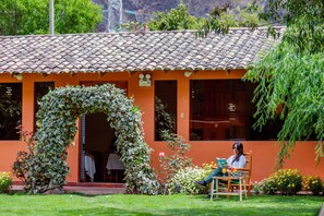 Un edificio con tejado de baldosas y un arco cubierto de hiedra.