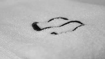 Un gros plan d’une serviette blanche ornée d’un logo noir brodé.