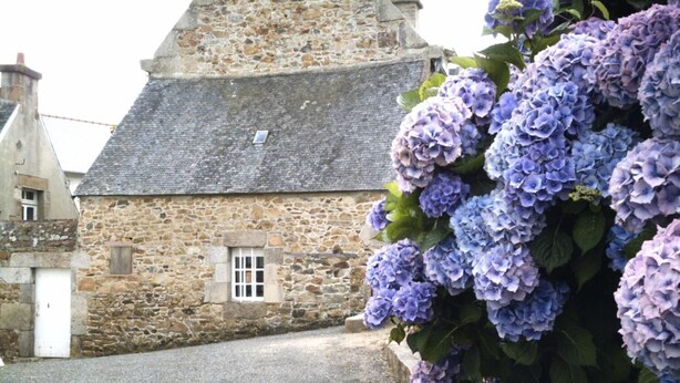 A stone building with a window and a door, surrounded by a gravel path. - Hermitage (Perros-Guirec)