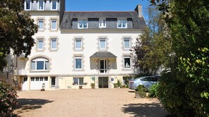 A multi-story building with a symmetrical facade, a central entrance, and a gravel driveway. - Hermitage (Perros-Guirec)